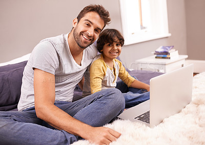 Buy stock photo Portrait of a father and son sitting on bed with their laptop