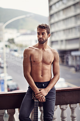 Buy stock photo Sexy, muscles and shirtless man on balcony, natural body and thinking male person with music idea and instrument outside. Confident, topless and abs in summer with guitar, standing in Puerto Rico
