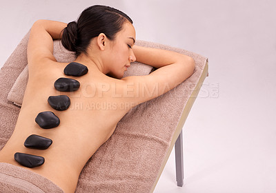 Buy stock photo Spa, woman and massage with hot stone therapy and wellness with vacation and stress relief. Natural, person and girl with peace or calm with holiday and weekend break with skin detox or luxury resort