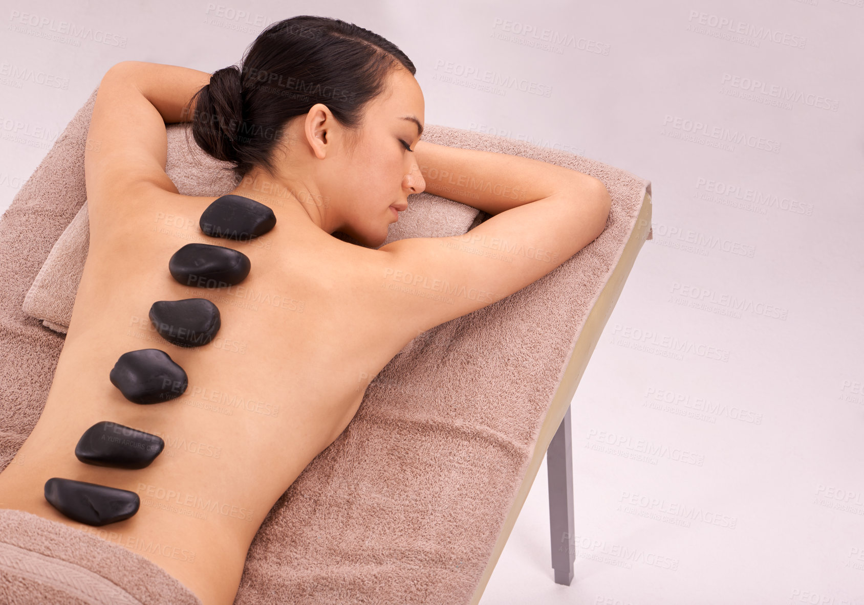 Buy stock photo Spa, woman and massage with hot stone therapy and wellness with vacation and stress relief. Natural, person and girl with peace or calm with holiday and weekend break with skin detox or luxury resort