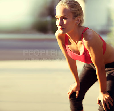 Buy stock photo An attractive young runner stand alongside a road