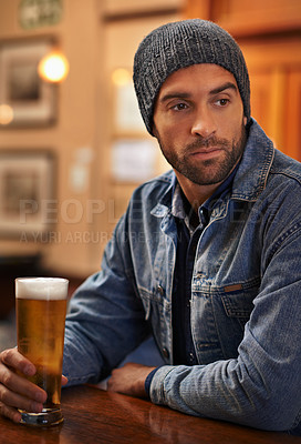 Buy stock photo Beer, thinking and male person at pub for drinks, restaurant and entertainment for fun. Pensive, alcohol and cafe for thoughtful or social for relax, pub and beanie for cold weather in England  