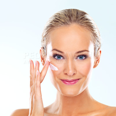 Buy stock photo Woman, studio and portrait with cream on face for skincare, dermatology, and self care with smile. Female person, happy and facial product with lotion, cosmetics or beauty glow on blue background