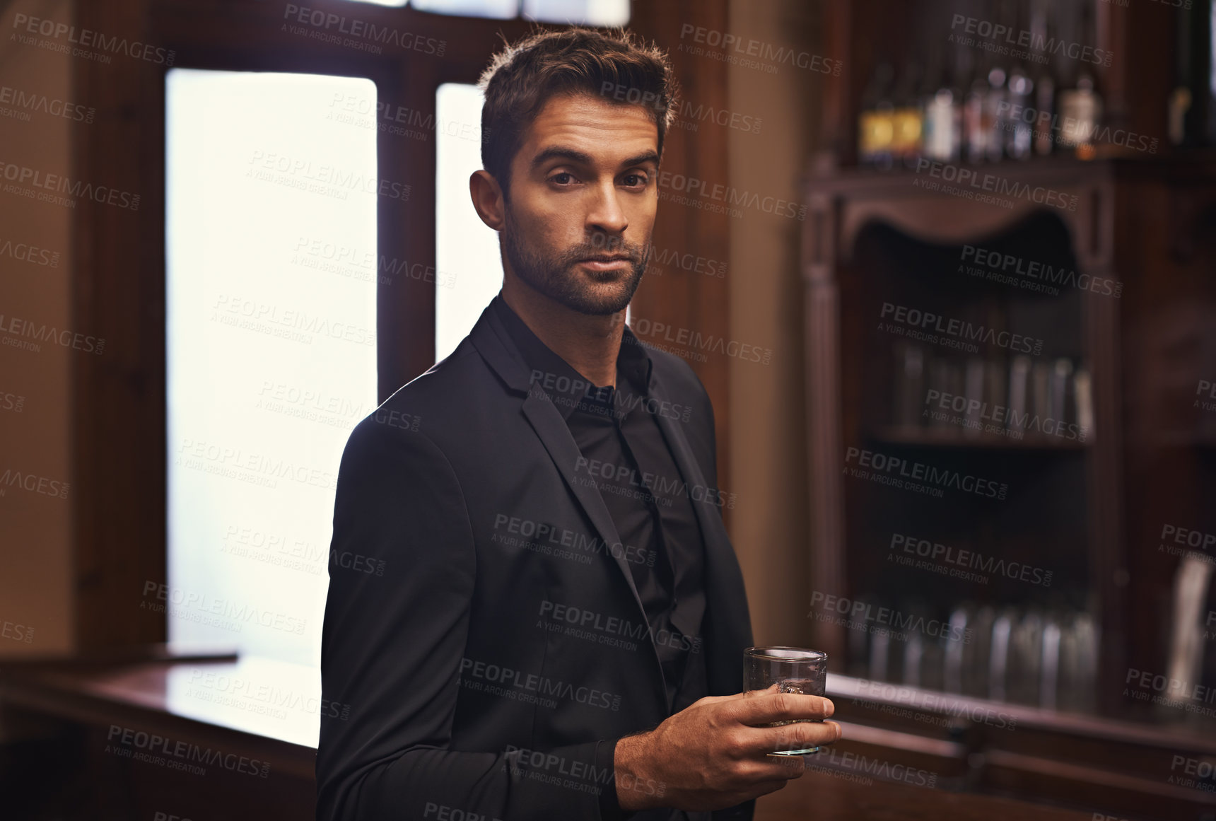 Buy stock photo Businessman, confident portrait or alcohol on break in hotel or drink to relax on corporate trip. Entrepreneur, pub or serious face by glass of whisky for leisure or young professional on work travel