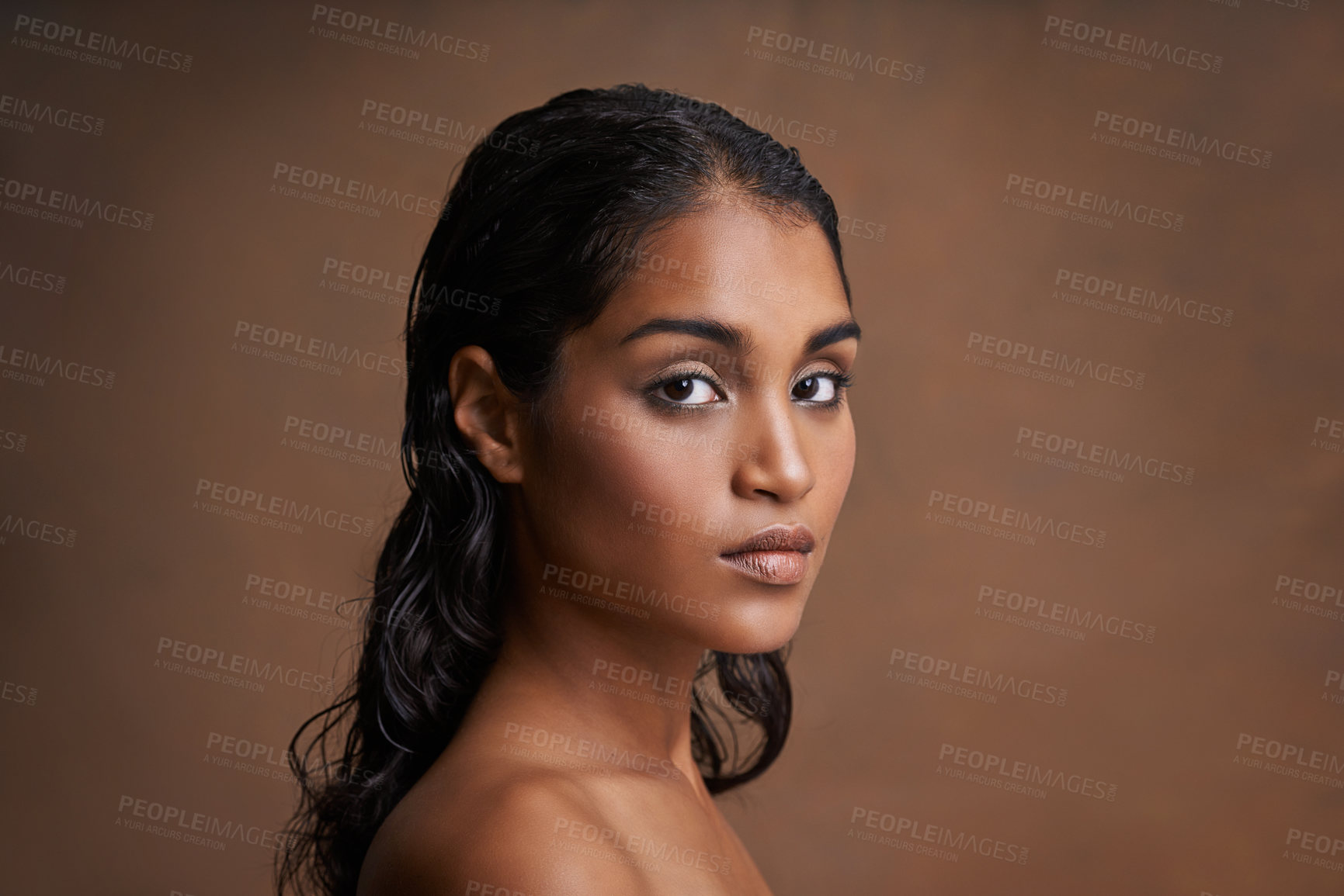 Buy stock photo Studio shot of a beautiful young woman against a brown background