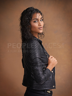 Buy stock photo Fashion, portrait and leather jacket with woman, confident and stylish clothes on brown studio background. Face, Indian person or model with mockup space and happy girl with makeup, bold or aesthetic