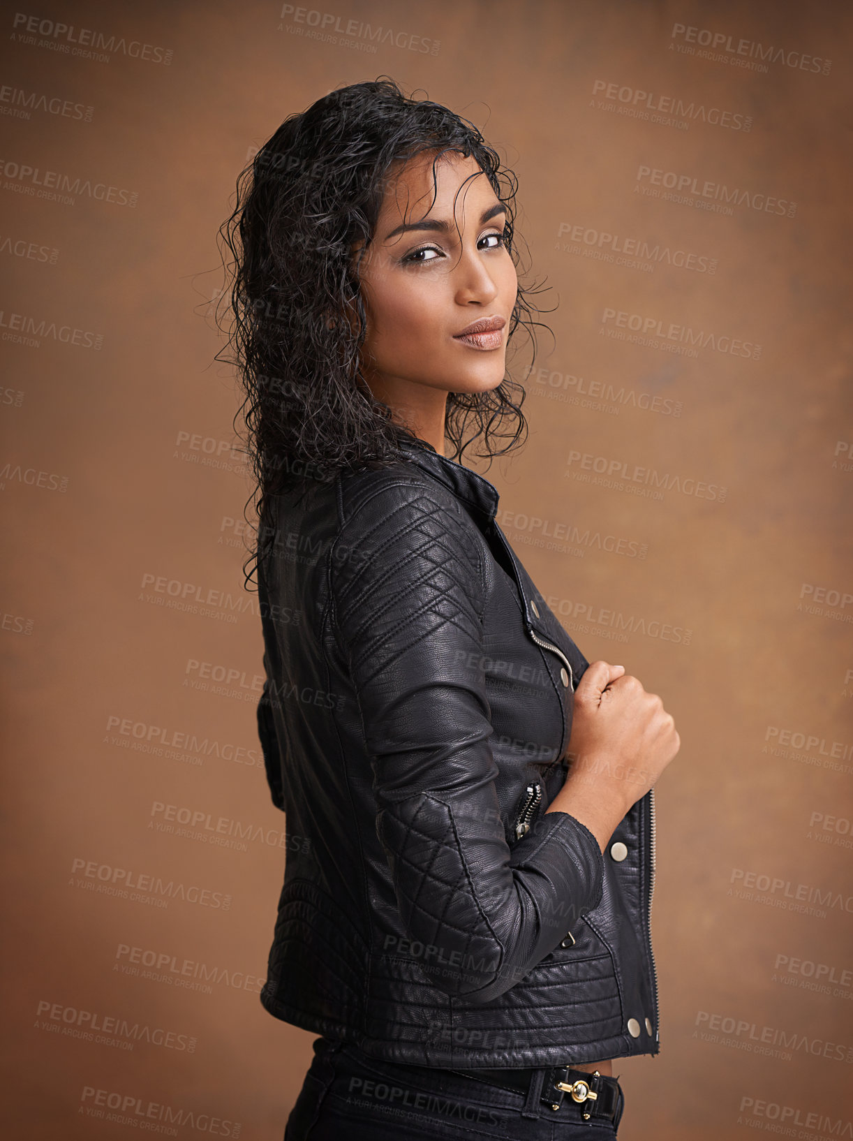 Buy stock photo Fashion, portrait and leather jacket with woman, confident and stylish clothes on brown studio background. Face, Indian person or model with mockup space and happy girl with makeup, bold or aesthetic