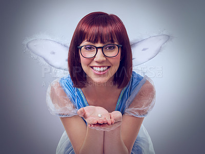 Buy stock photo A cropped shot of a fairy godmother in a blue gown holding a tooth