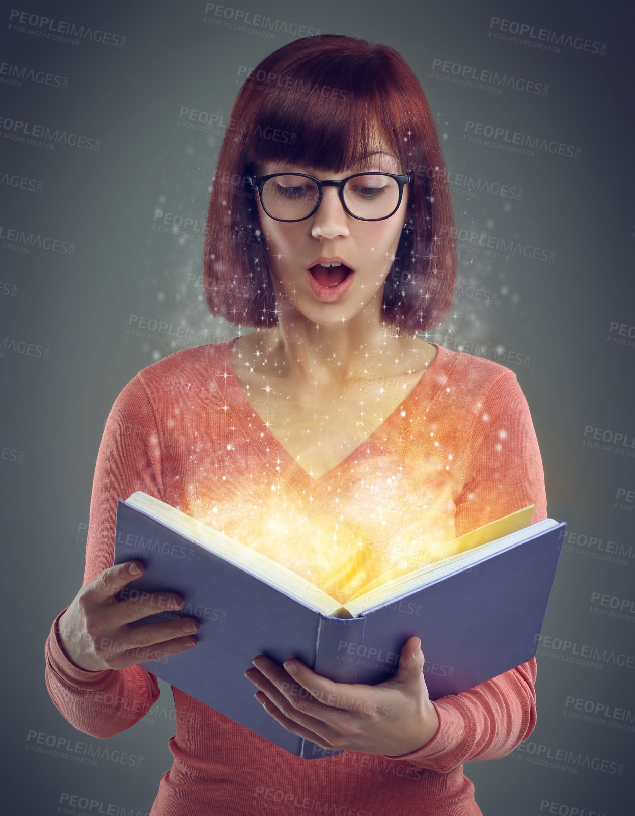 Buy stock photo A cropped shot of a young adult reading a book with glowing pages