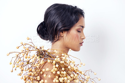 Buy stock photo Studio shot of an attractive young ethnic woman with foliage over her shoulder