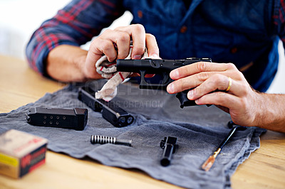 Buy stock photo Cropped view of a man cleaning his gun