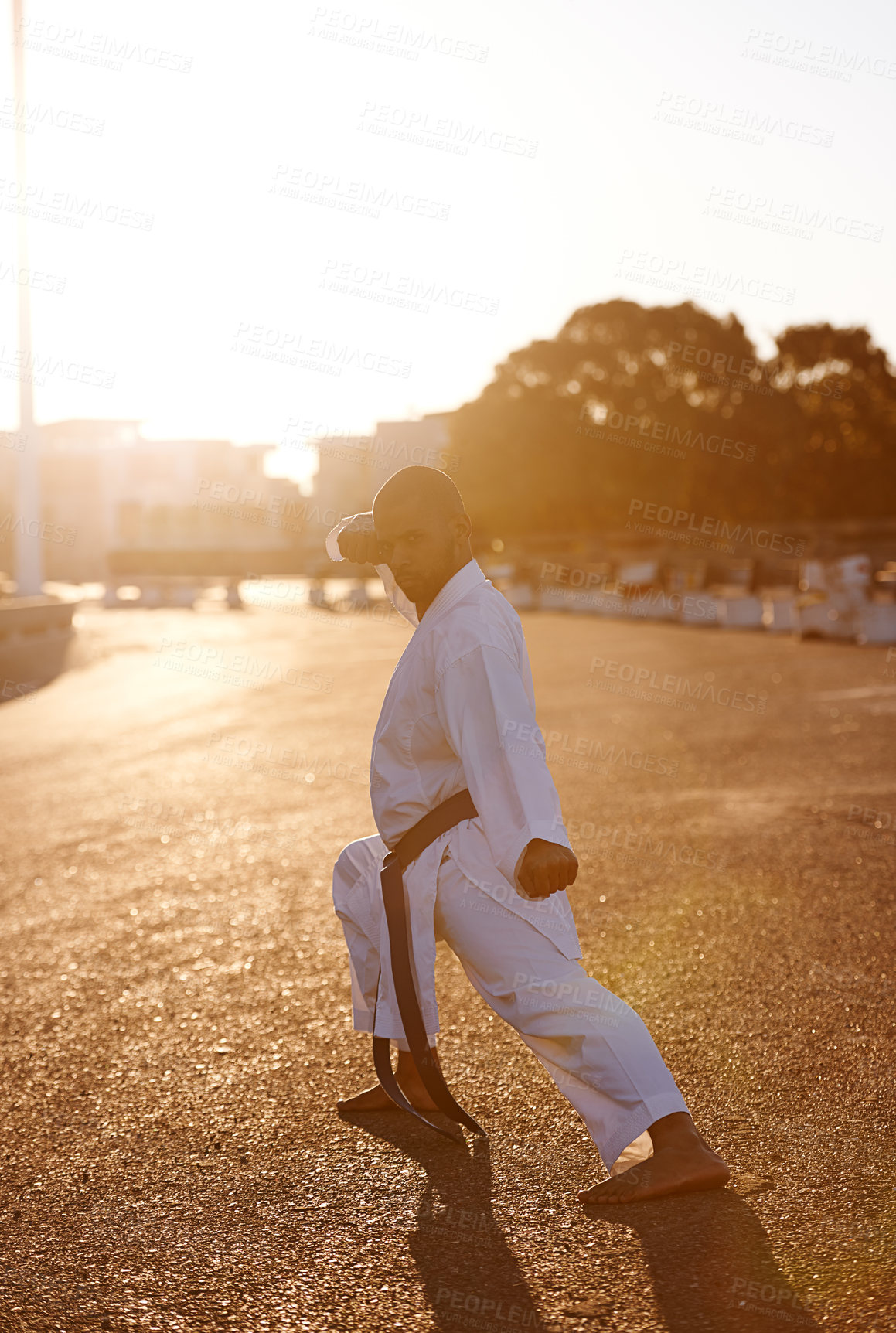 Buy stock photo Man, martial arts and karate in street for portrait with fist, balance or warrior for battle in city. Person, contact sports and fight with power, conflict and self defence in road, outdoor or sunset