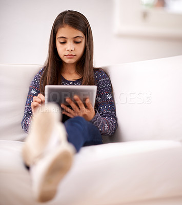 Buy stock photo Relax, sofa or girl with tablet for elearning, playing games or streaming videos on a movie website. Education, online or child in home with technology to download on app or reading ebook on couch