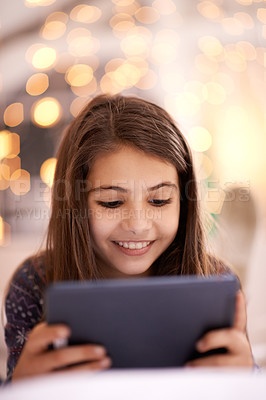 Buy stock photo Home, night or kid with tablet for movies, playing games or watching fun videos on streaming website. Girl, house or young female child with technology to download online or social media app to relax