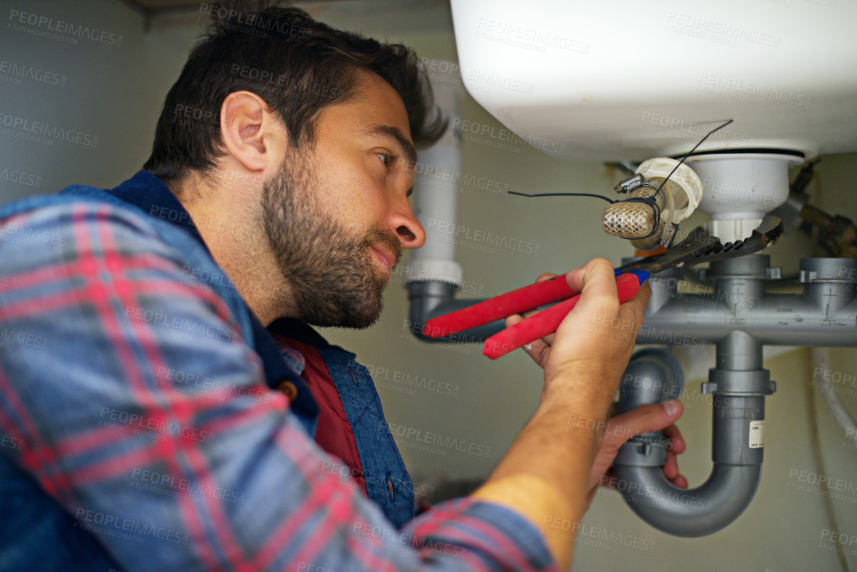 Buy stock photo Man, plumber and wrench with pipe for repair, service or fix in home maintenance or indoor leak. Young male person, handyman or plumbing professional with tool for water or sink damage at the house