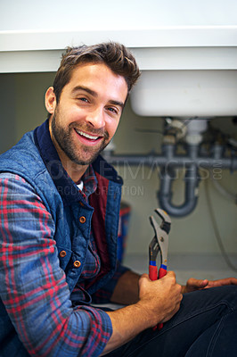 Buy stock photo Shot of a plumber fixing a pipe