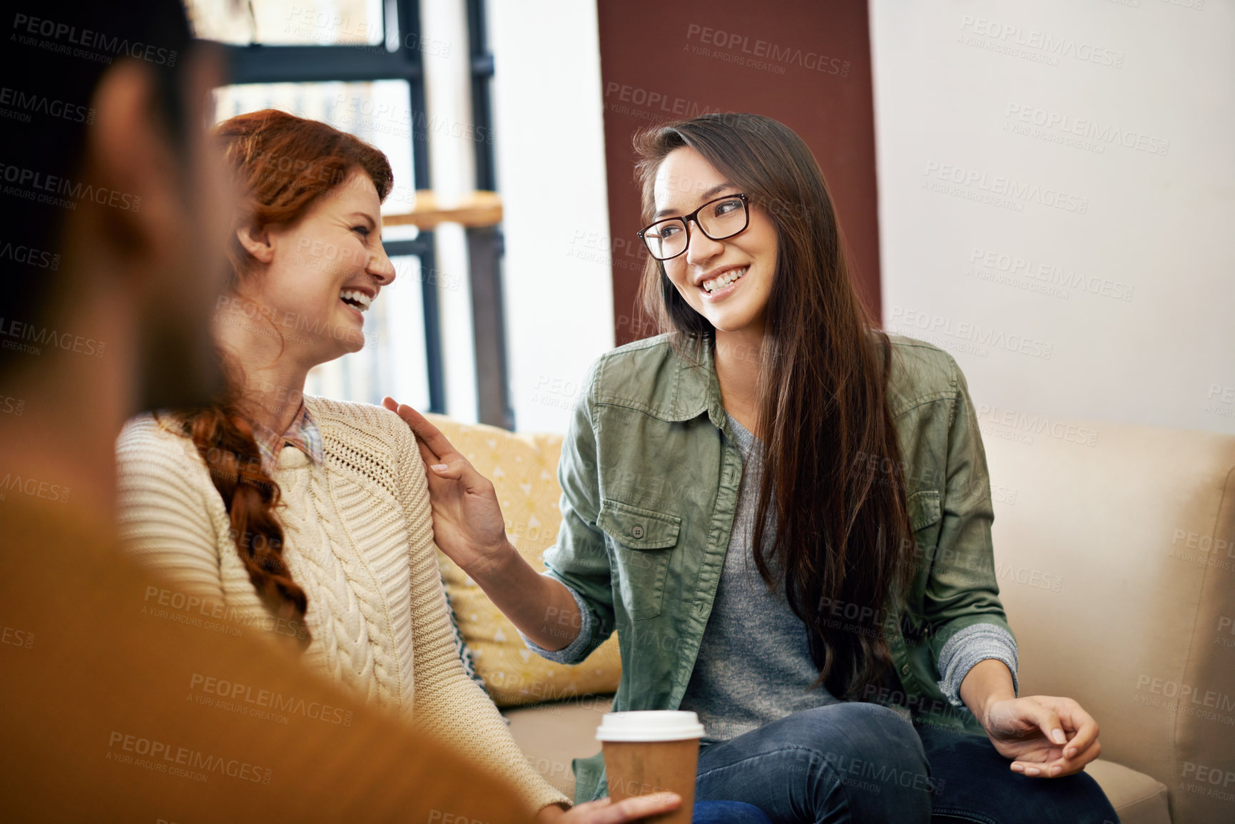 Buy stock photo Happy woman, friends and laughing with coffee on sofa for funny joke, humor or comedy together. Female person or group with smile in happiness for social bonding, talk or chatting at cafe lounge