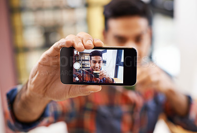 Buy stock photo Cropped shot of a handsome young man taking a selfie