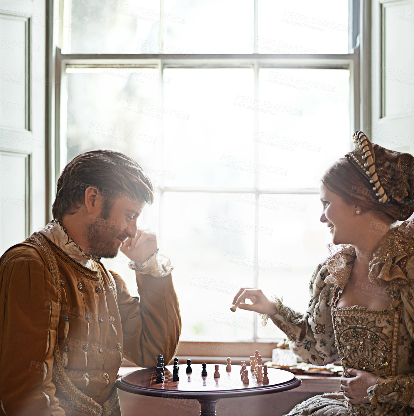 Buy stock photo Renaissance, couple and chess at home with royalty, vintage and medieval costume in a palace. Window, luxury and queen together with smile from strategy game and talking while playing with love