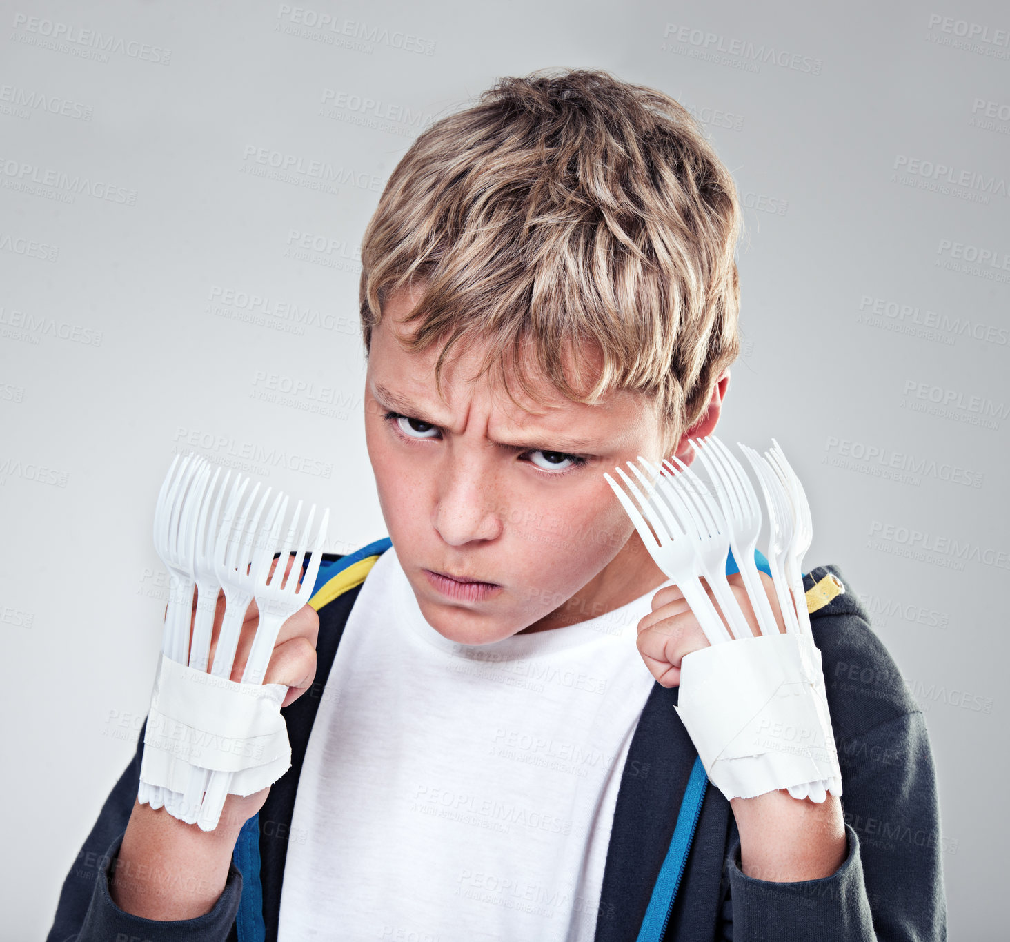 Buy stock photo Portrait, angry and boy with fist, fight and expression with frustrated on grey studio background. Face, model and kid with forks for claws and reaction with costume and aggressive with rage or child