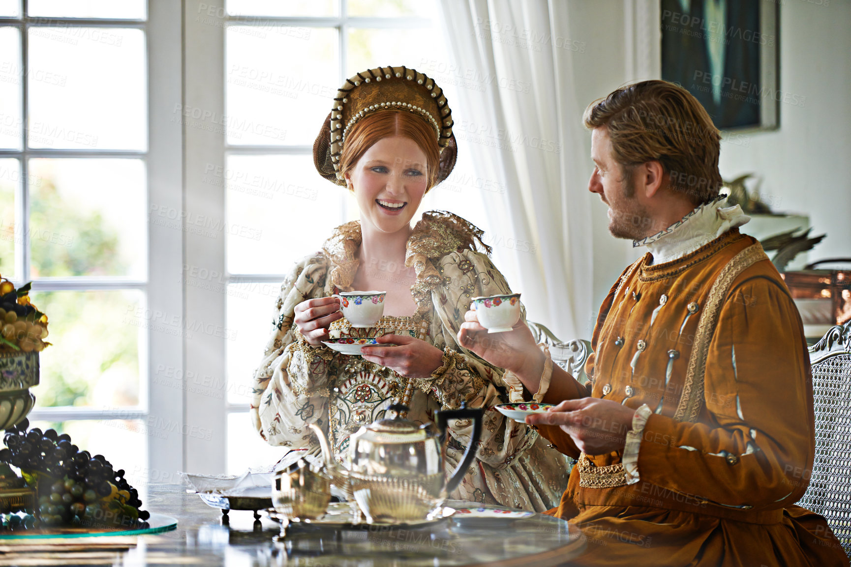 Buy stock photo A king and queen taking tea together at home