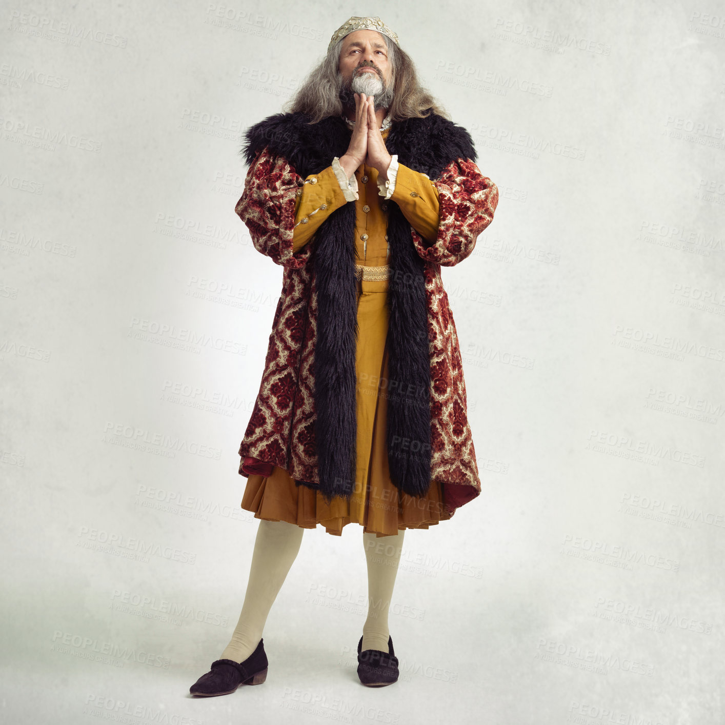 Buy stock photo Ancient king man, praying and studio with faith, worship and renaissance fashion by backdrop. Medieval royal leader, clothes and religion with crown, prayer and robe for power, success and gratitude