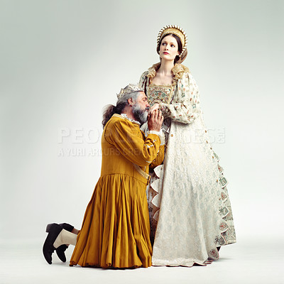 Buy stock photo Studio shot of a king kneeling and kissing his queen's hand