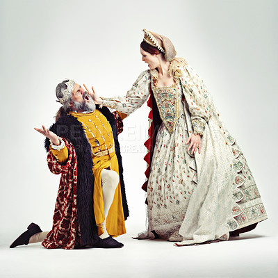 Buy stock photo Studio shot of a queen slapping a kneeling king in the face