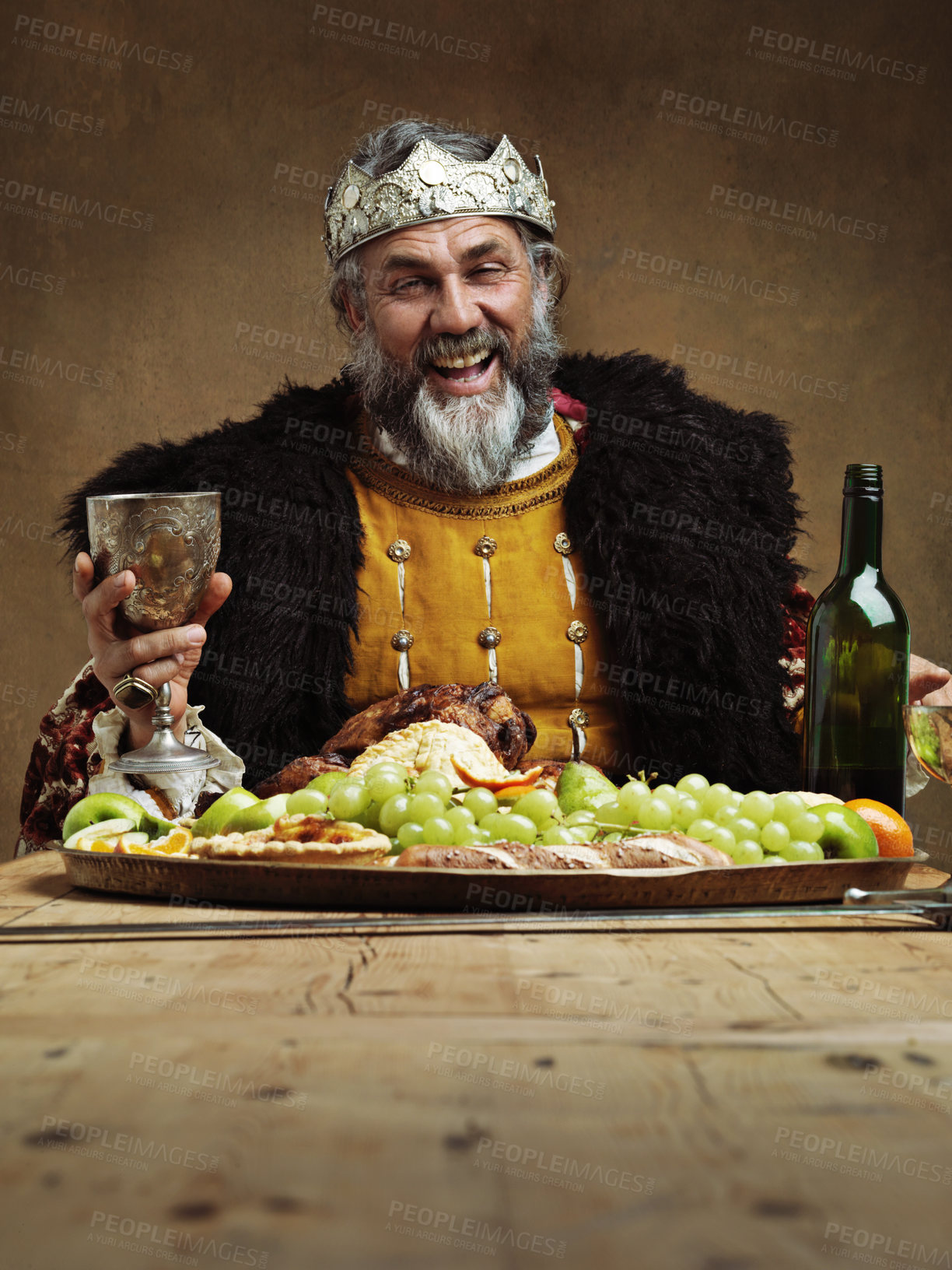 Buy stock photo King, feast and happy in table with wine glass as lord on dining hall for tradition, culture and meal in palace. Portrait, monarch and leader with eating buffet or supper in royal party with crown 