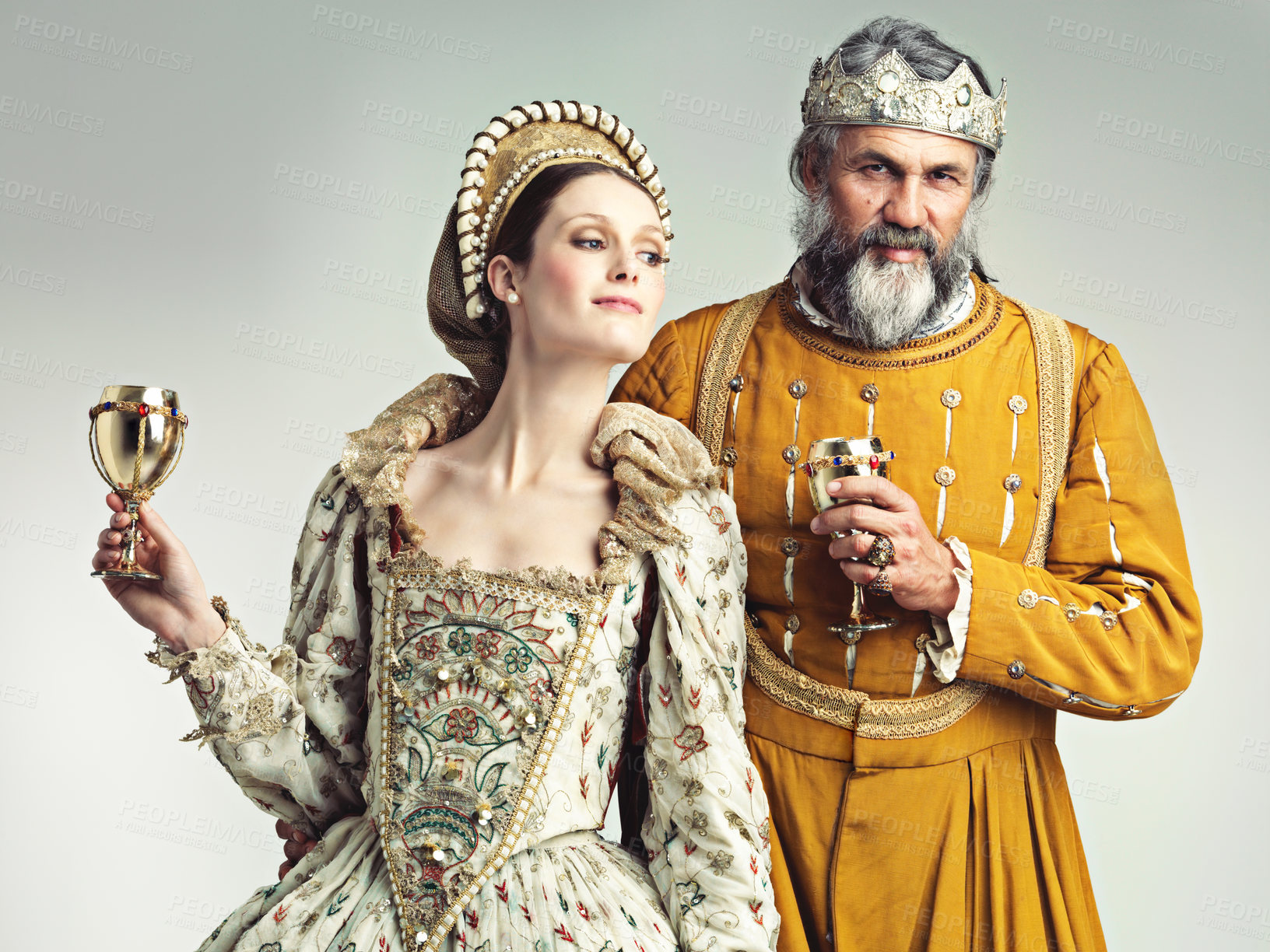 Buy stock photo Studio shot of a king and queen drinking out of goblets