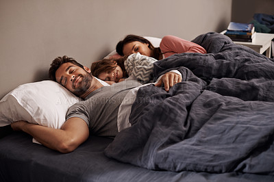 Buy stock photo Shot of a little girl sleeping beside her parents in bed