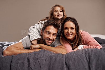 Buy stock photo Parents, child and portrait in bedroom to relax in home for weekend break, family time and happiness for bonding. Father, mother and girl comfy or cozy together for love, care and safety or security.