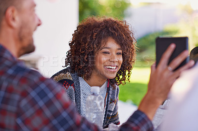 Buy stock photo A young woman looking at a friend's phone
