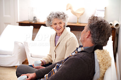 Buy stock photo Senior couple, coffee or couch to relax in conversation of happy, memory or bonding together. Older woman, man or tea on sofa to talk, plan or thinking of dream retirement vision in living room