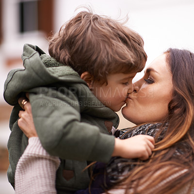 Buy stock photo Shot of a beautiful mother lifting her young son and giving him a kiss