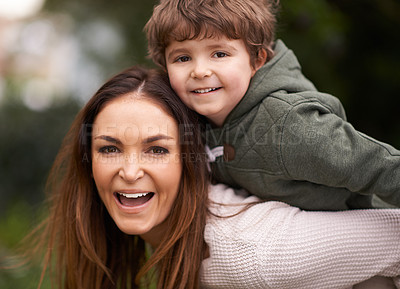 Buy stock photo Shot of a beautiful mother giving her son a piggyback ride outdoors
