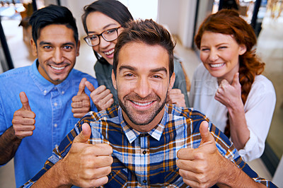 Buy stock photo Shot of a team of young designers showing thumbs up at the camera