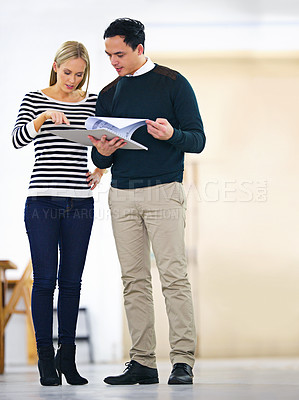 Buy stock photo Shot of two colleagues talking together in an office
