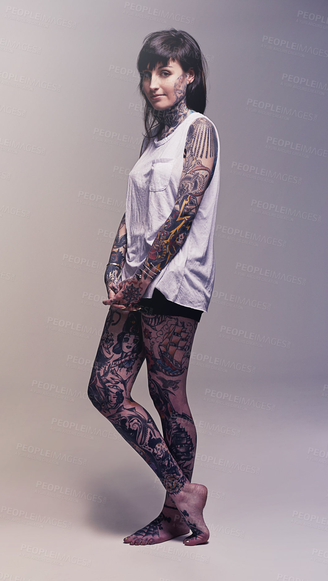 Buy stock photo Studio shot of a young woman covered in tattooes