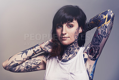 Buy stock photo Portrait, tattoo and edgy with a woman in a tank top on a studio gray background for contemporary style. Fashion, body art and punk with an attractive young female model posing to show her ink