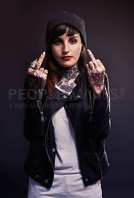 Buy stock photo Portrait, fashion woman with middle finger, tattoo or attitude in studio with gothic, style or artistic expression on black background. Rebel, face and emo model with hand, emoji or grunge aesthetic