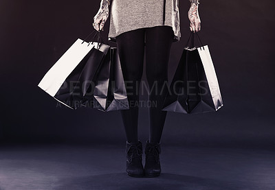 Buy stock photo Woman, legs and shopping bags for fashion in studio on dark background with retail, discount and clothes. Female person, tattoo and edgy style with creative look, body ink and art for self care 