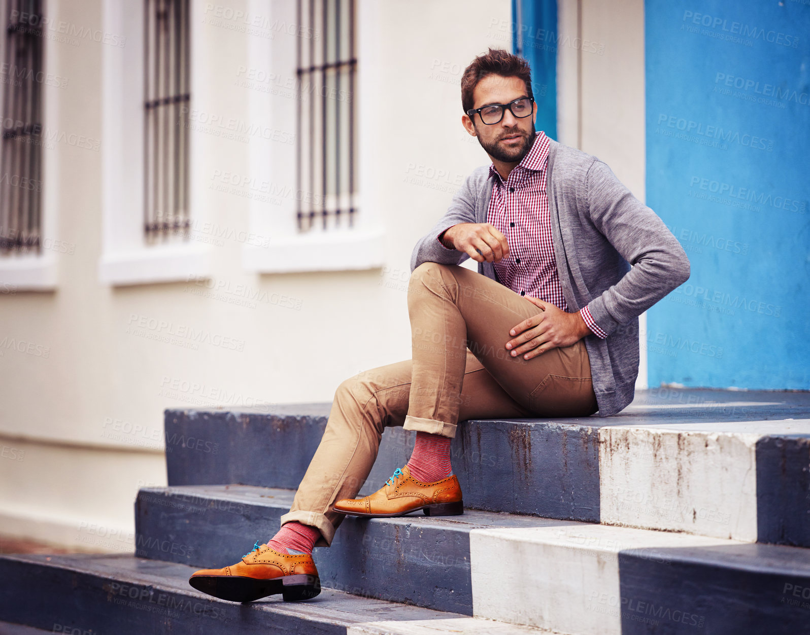 Buy stock photo Shot of a handsome young man sitting on steps