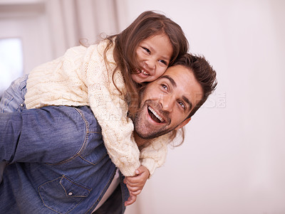Buy stock photo Shot of a father giving his daughter a piggyback ride at home