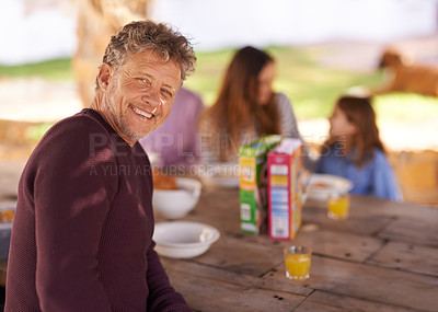 Buy stock photo Portrait, mature and man with smile for picnic with family in nature of backyard of house and outdoor. Women, men and child eating breakfast on table of wood in summer, happiness and love in home