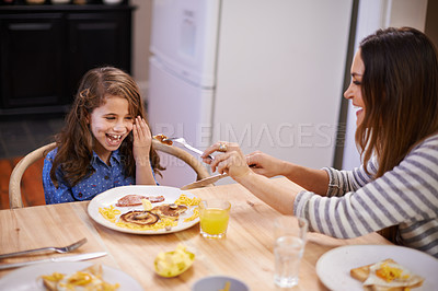 Buy stock photo Mom, child and laugh in morning with breakfast for routine with quality time, happiness and nutrition. Mother, girl and together for bonding with food, feeding and homemade with love for healthy diet