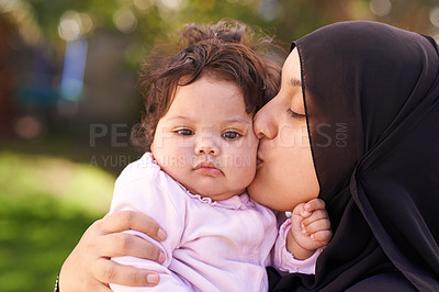 Buy stock photo Muslim woman, mother and baby kissing for love, care and bonding during Eid in Cape Town, South Africa. Female person, child and family together outdoor in nature, garden and backyard with affection