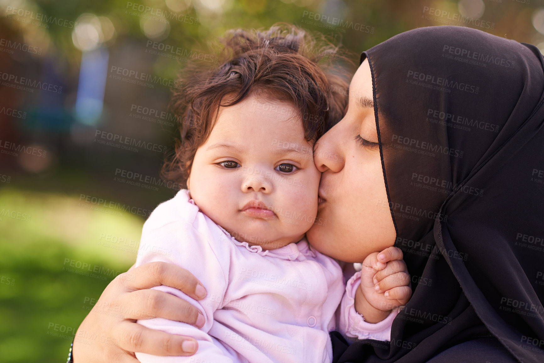 Buy stock photo Muslim woman, mother and baby kissing for love, care and bonding during Eid in Cape Town, South Africa. Female person, child and family together outdoor in nature, garden and backyard with affection