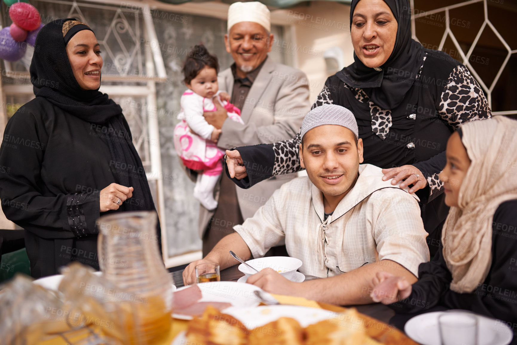 Buy stock photo Muslim family, Eid and lunch by table with food for celebration, conversation and eating together. Islamic people, culture and religious holiday with meal for special event, love and nutrition