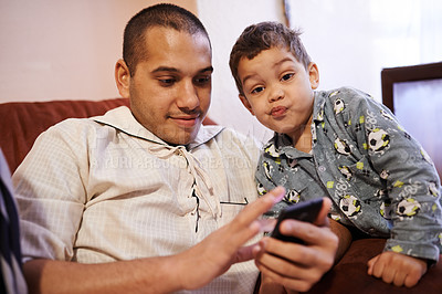 Buy stock photo Child, muslim father and smartphone in home for playing games, bingo or communication with technology. Family, dad and kid in portrait on sofa in living room for bonding, love and relax together